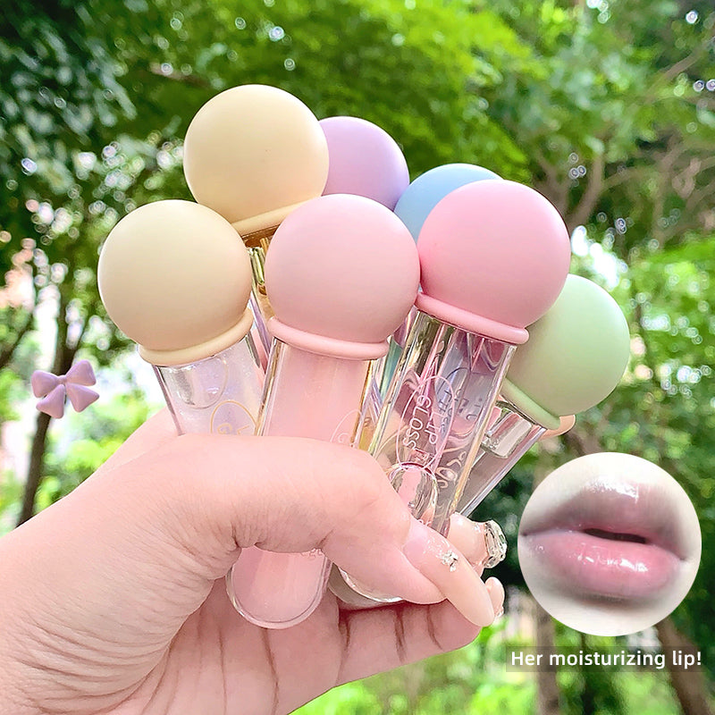 Set of colorful lip balms held by a hand with a blurred green outdoor background