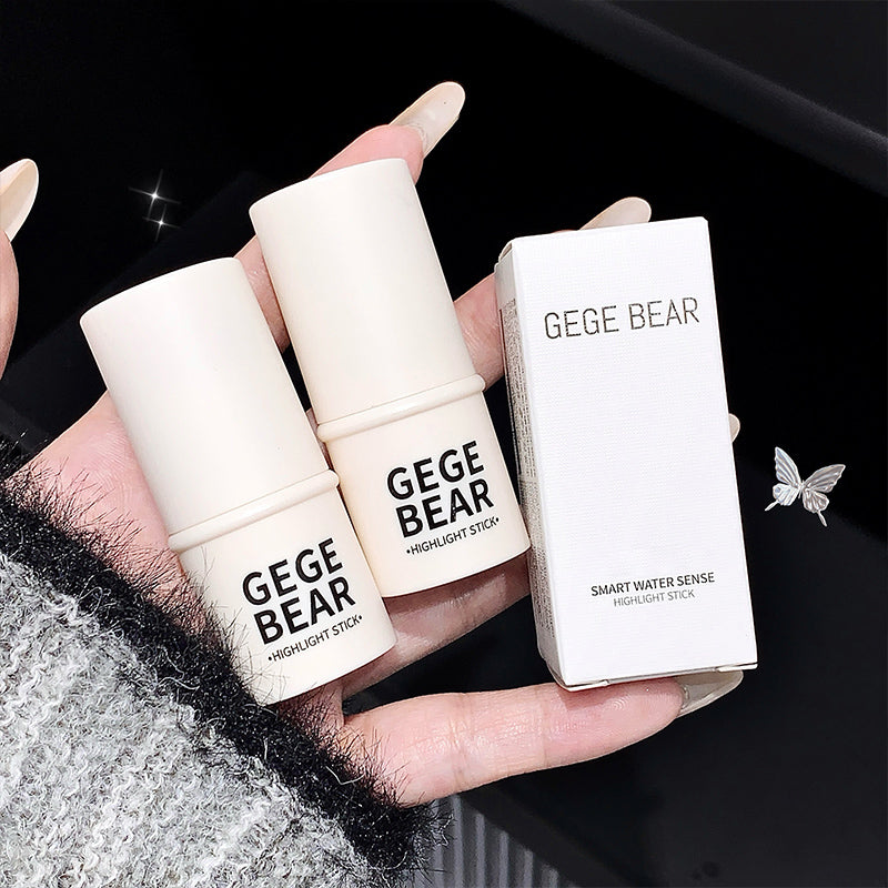 Hand holding two 'GEGE BEAR' highlight sticks and their packaging against a dark background.