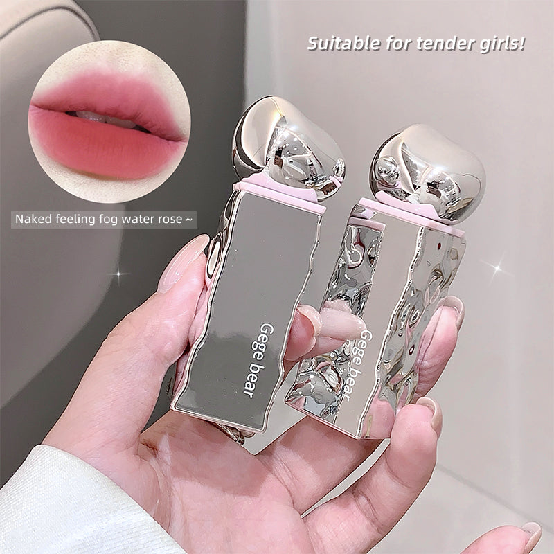 Hand holding a silver and pink lip gloss with close-up of lips and product.