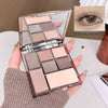 Makeup palette with six colors held by a hand, close-up of eye makeup application.