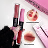 Two GEGE BEAR lip glosses held by a hand with a pink background showing product swatches.