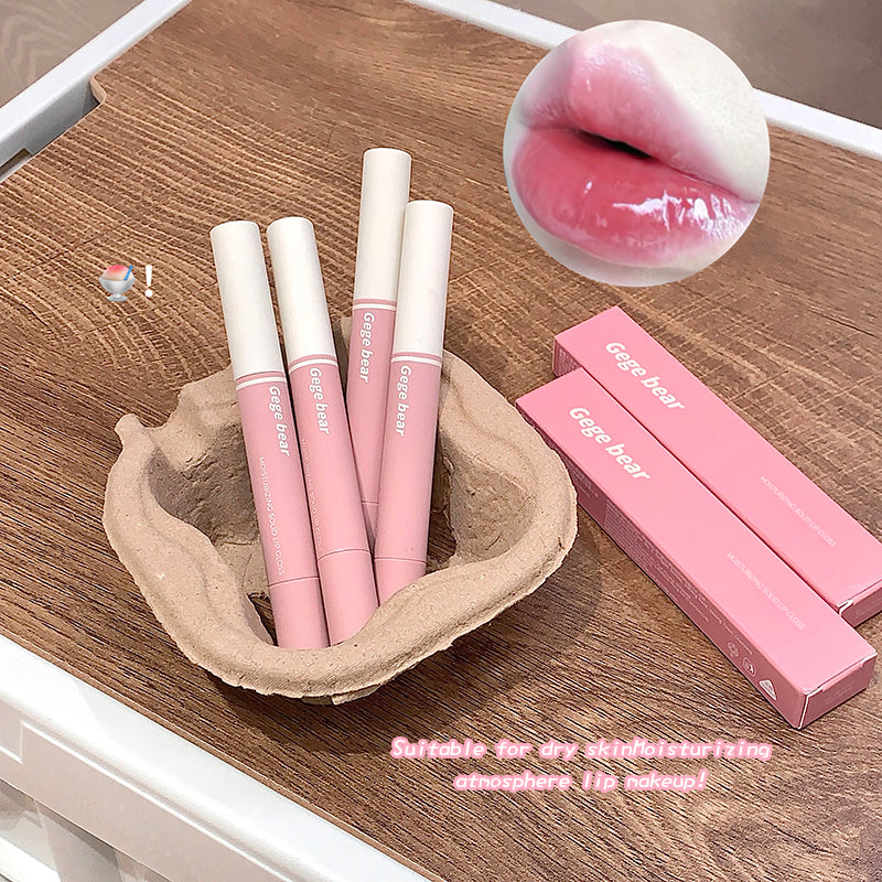 Pink lip glosses with white caps on a wooden surface, one of which is shown applied to lips.