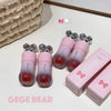 Pink and red gradient lip gloss with packaging on a light surface, featuring the brand 'GEGE BEAR'.
