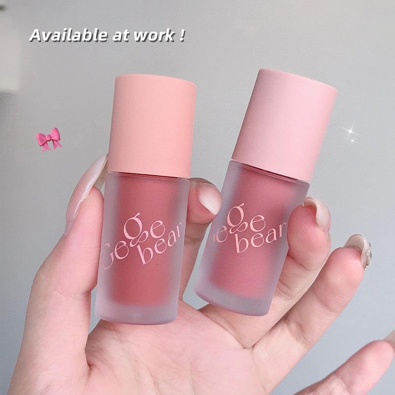 Two pink lip products with 'gege bear' branding held in a hand against a gray background.