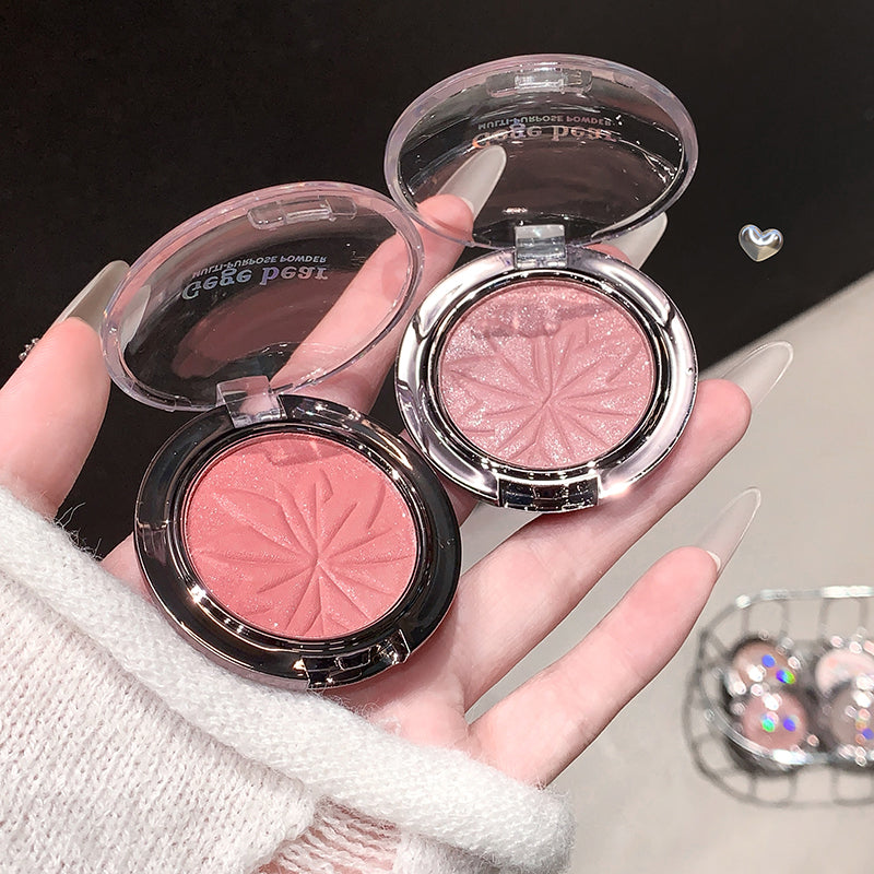 Two pink makeup compacts held in a hand with a blurred background