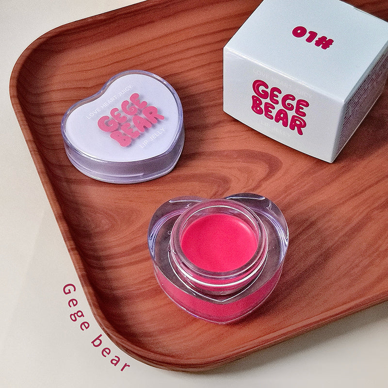 Pink lip balm container with heart-shaped lid on a wooden tray, featuring 'Gege Bear' branding.