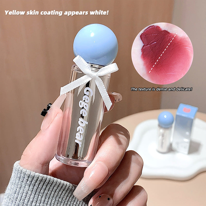 Hand holding a cosmetic bottle with a small mirror, showing close-up of texture and color correction text.