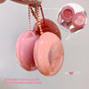 Pink and peach-colored lip balm with beads, showing how it opens and can be used as a pendant.
