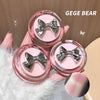 Pink lip balm with silver bows held by a hand, brand 'GEGE BEAR' visible