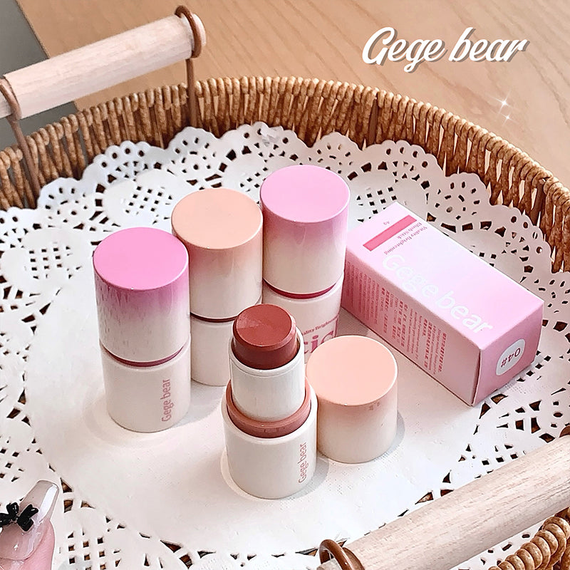 Set of cosmetic products including lipsticks and a box on a decorative doily with 'Gege bear' branding.