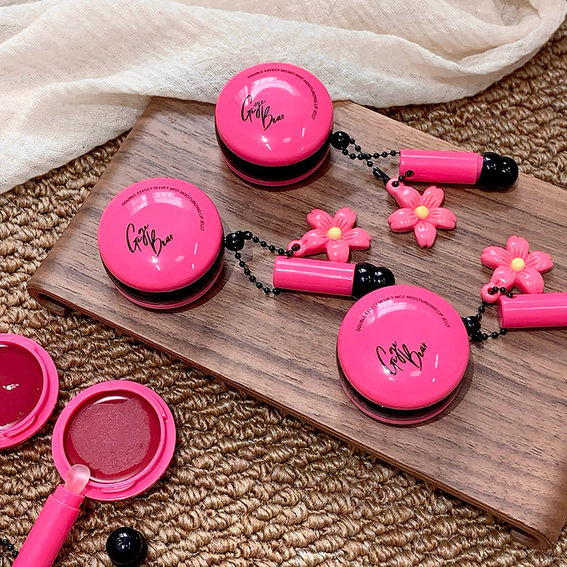 Pink makeup set with floral designs on a wooden board and beige fabric background