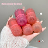 Hand holding four small lip gloss containers with 'GECE BEAR' branding on a neutral background.