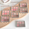 Multiple makeup palettes with pink and brown shades on a wooden surface