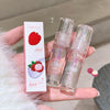 Two lip oil products and their packaging held in a hand with a neutral background.