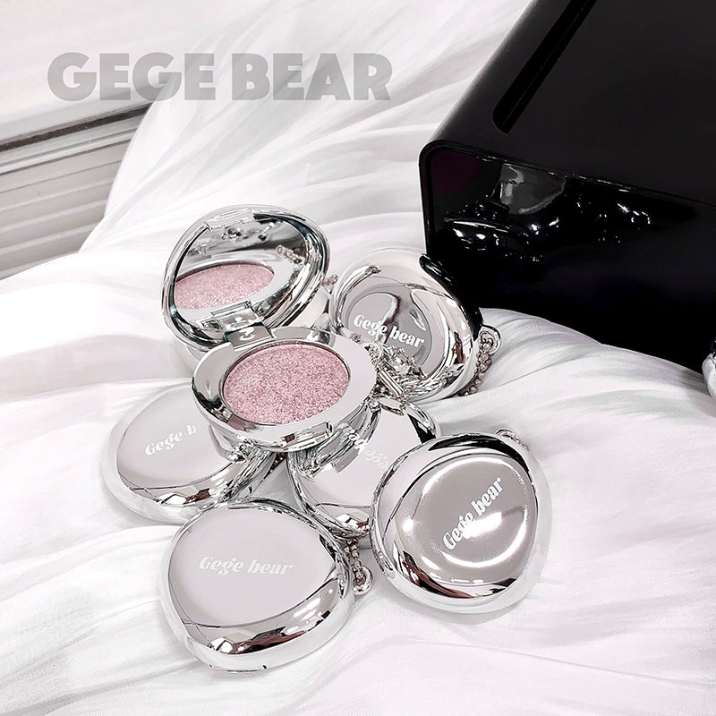 Makeup products with 'GEGE BEAR' branding on a white fabric background