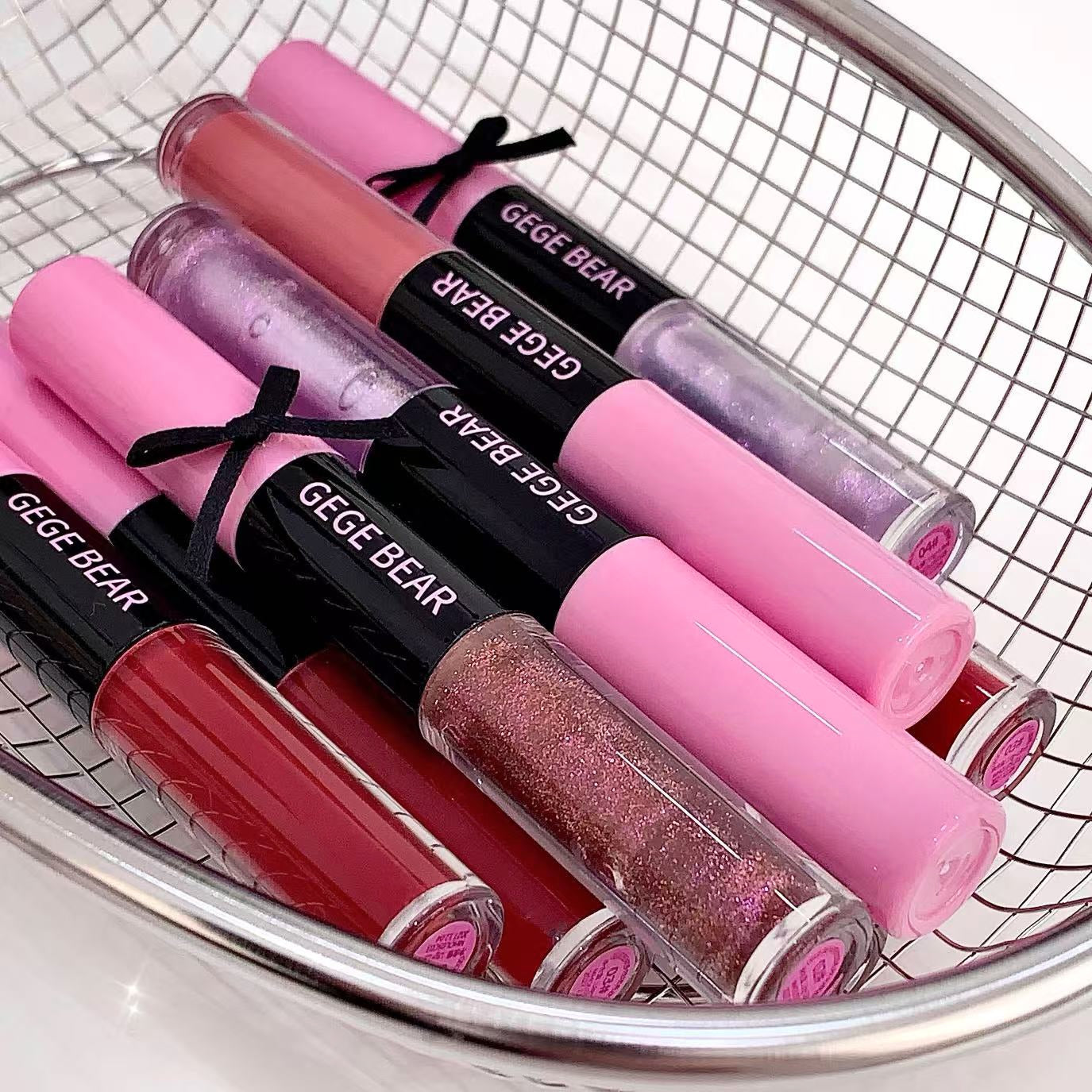 Set of GEGE BEAR lip glosses in various colors on a white background