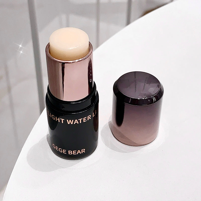 Cosmetic stick with rose gold cap and black body on a white surface