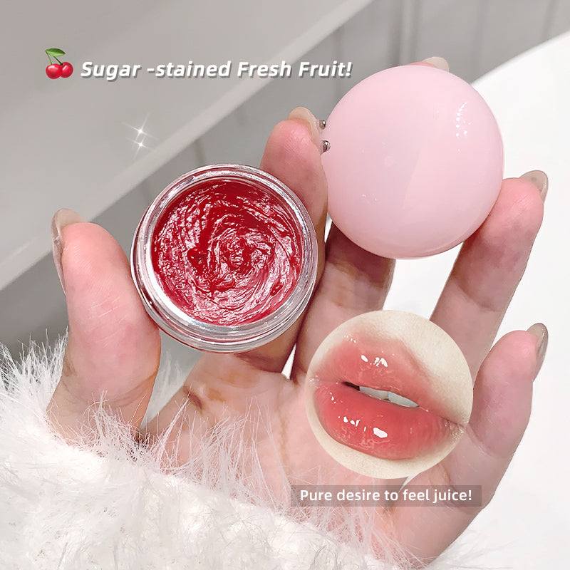 Lip balm and container with red substance held by a hand, labeled 'Sugar-stained Fresh Fruit' and 'Pure desire to feel juice!'.