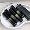Set of black and green lip glosses with a box on a white plate, featuring 'Gege Bear' branding.