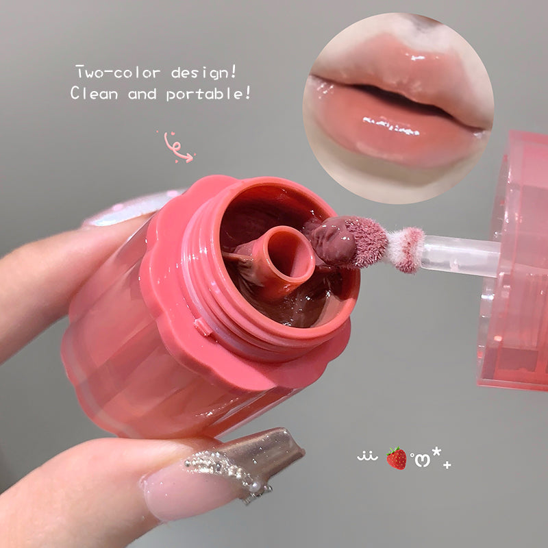 Pink lip balm with two-color design being applied to lips, on a gray background.