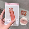 Hand holding a pink lip gloss with packaging and close-up of product on a neutral background