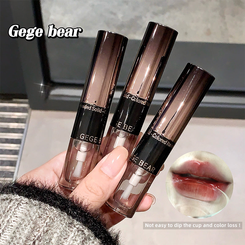 Three lip gloss tubes held by a hand with a blurred background