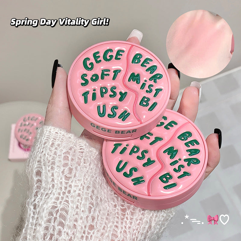 Pink compact mirror with text held by a hand, featuring the brand 'GEGE BEAR'.