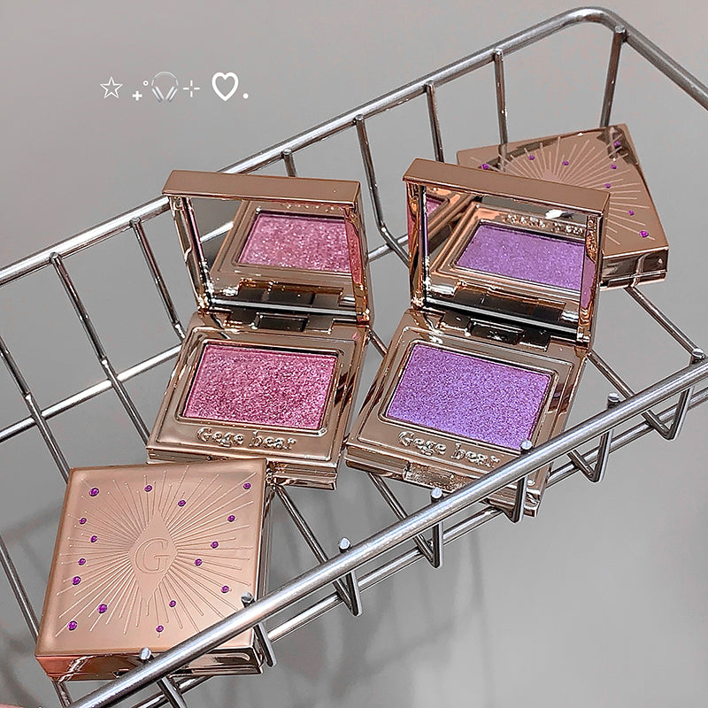 Makeup products with pink and purple shades on a metal rack.