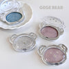 Makeup products with bear-shaped cases on a white background, featuring the brand 'GEGE BEAR'.