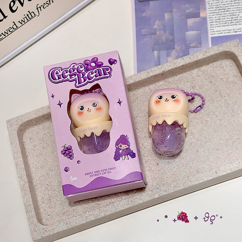 Gege Bear lip balm with packaging on a textured surface