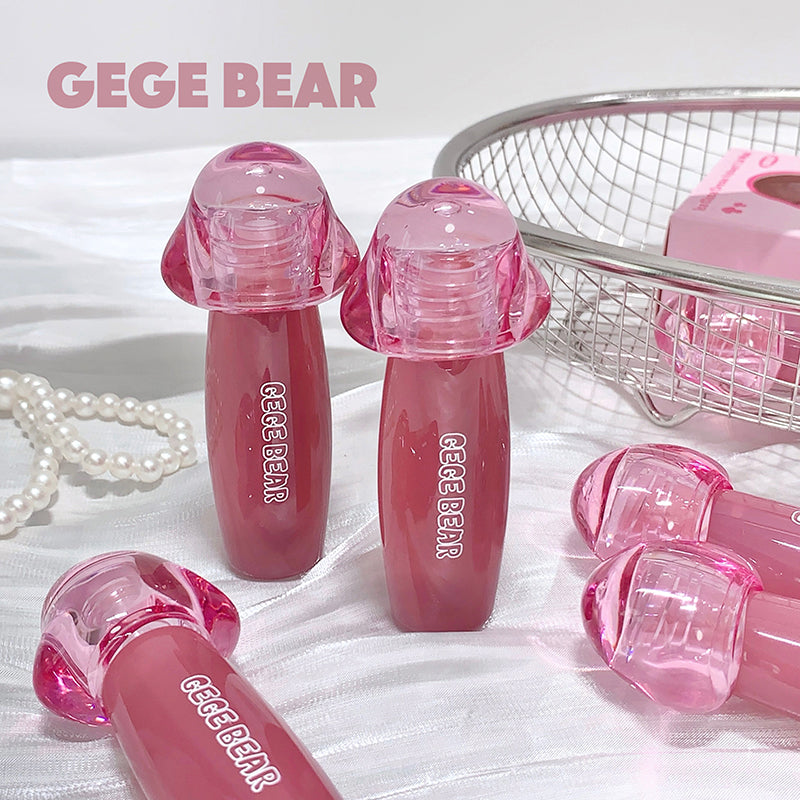 Pink GEGE BEAR products on a white surface with pearls and a basket in the background.