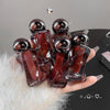 Hand holding a set of Gege bear figurines with a gray background