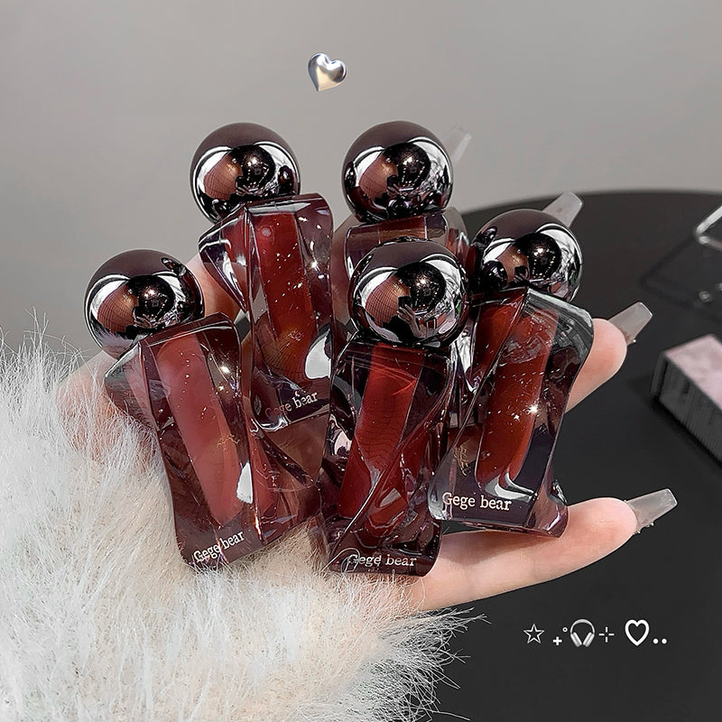 Hand holding a set of Gege bear figurines with a gray background