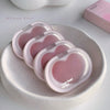 Pink heart-shaped containers with 'Gege bear' branding on a white plate.