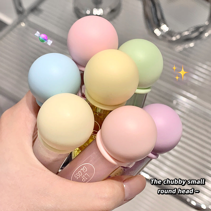 Hand holding a small round head product with colorful heads on a reflective surface