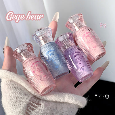 Five small bottles of nail polish in pink, blue, and purple held by a hand.