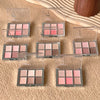 Multiple makeup palettes with shades of pink, brown, and beige on a textured surface.