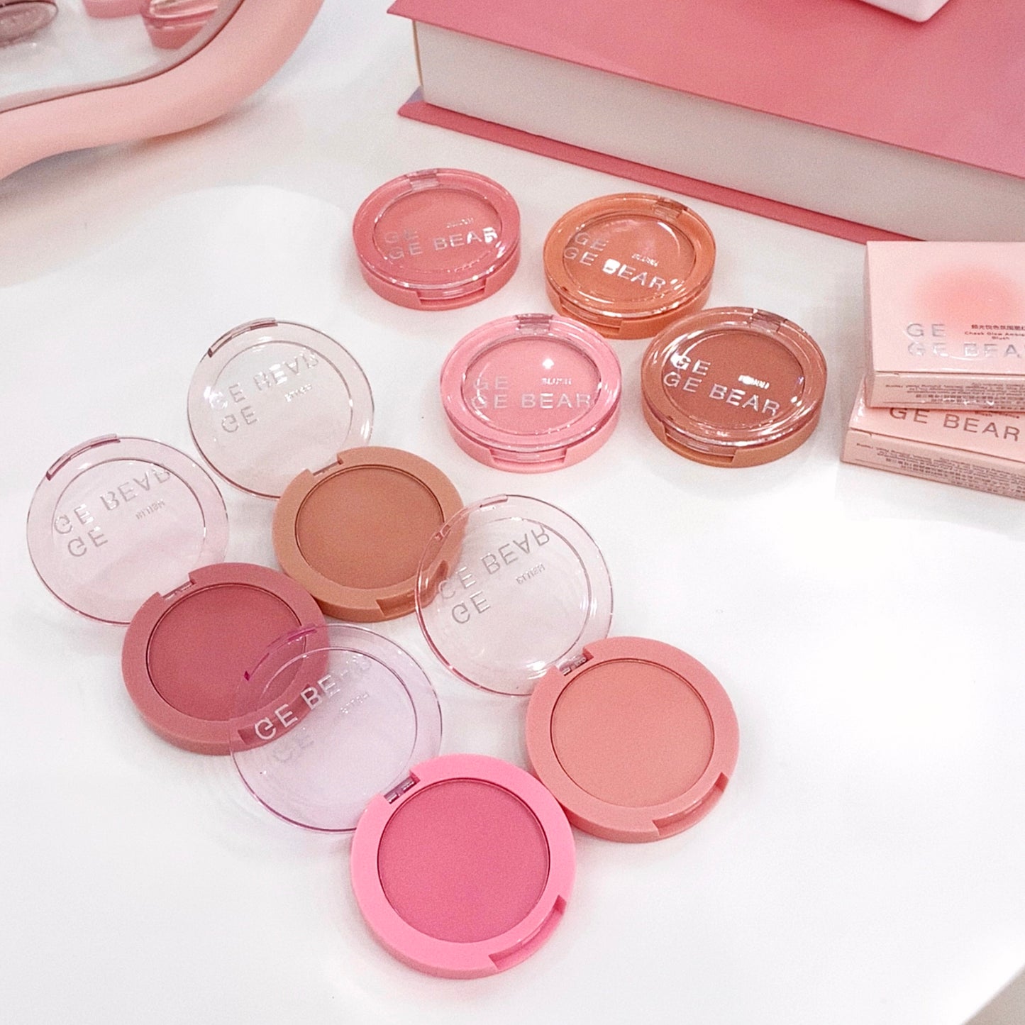Multiple blush compact cases with 'BE BEAR' branding on a light background