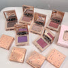 Multiple open cosmetic compact cases with glittery eyeshadows on a white surface.
