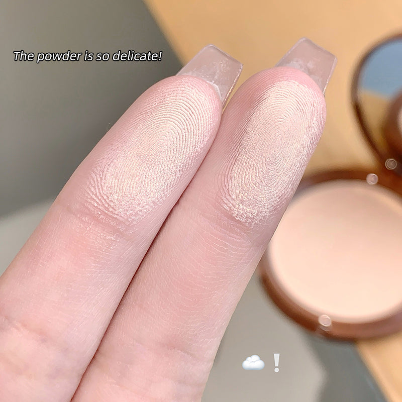 Close-up of fingers with light makeup and a compact powder case.