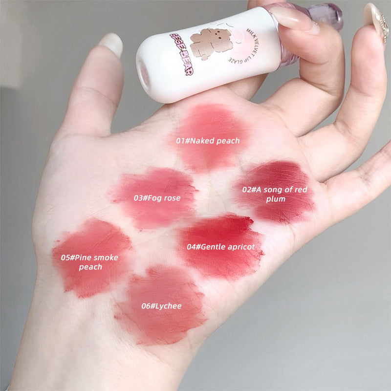 Hand with lipstick swatches labeled and a small bottle of lipstick.