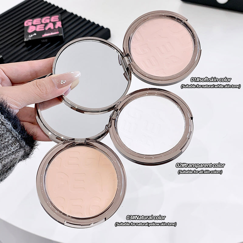 Compact powder with three color options held by a hand on a white background