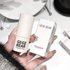 Hand holding a 'GEGE BEAR' highlight stick with its packaging on a white surface.