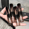 Hand holding four GEGE BEAUTY lip glosses with a blurred background