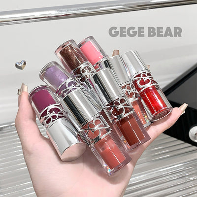 Hand holding six lipsticks with metallic caps, displayed against a blurred background with 'GEGE BEAR' branding.