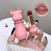Pink bear-shaped lipstick case held by a hand with a close-up of lips and cherry emoji.