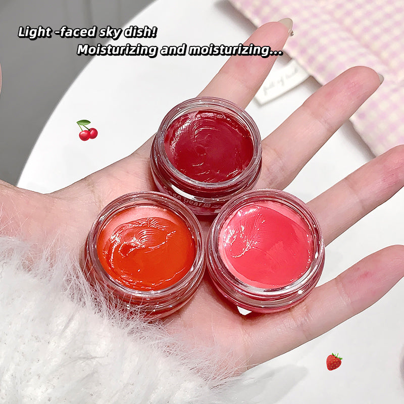 Three small jars of red and pink lip balm on a hand with text about moisturizing.