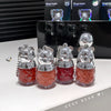 Four GEUGE BEAR keychains with red liquid and silver tops on a white surface.
