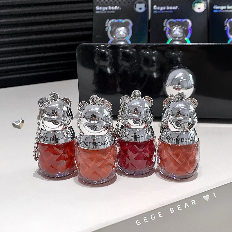 Four GEUGE BEAR keychains with red liquid and silver tops on a white surface.