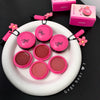 Set of pink makeup products with 'Gege Bear' branding on a white plate.